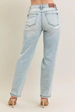 Light blue jeans worn by a person on a beige background