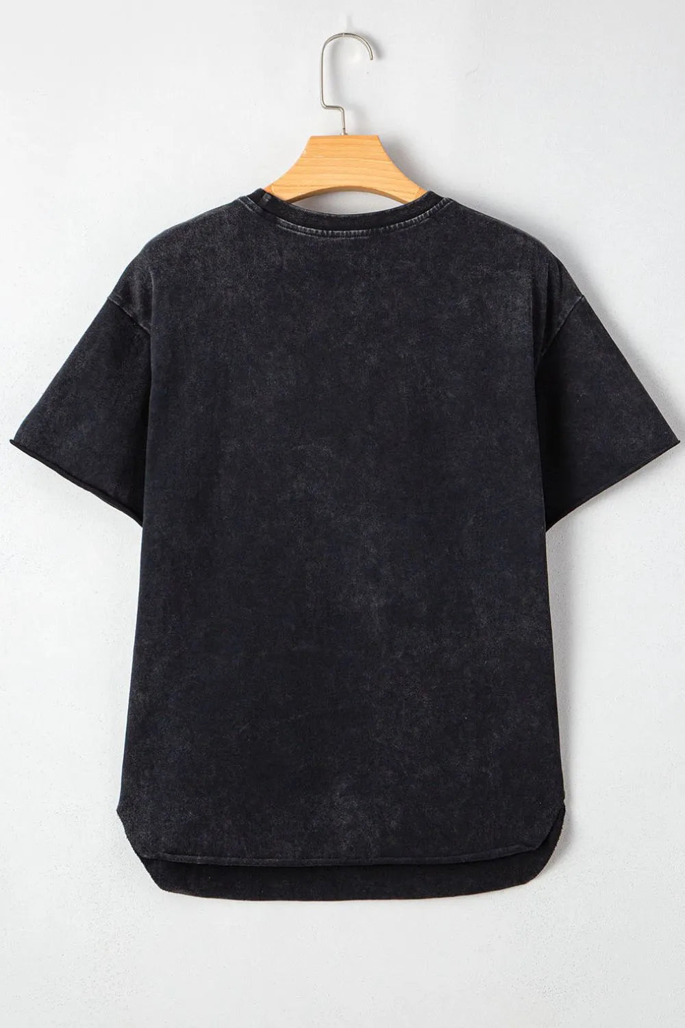 Black t-shirt on a wooden hanger against a white background