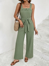 Woman wearing a green jumpsuit with a white background