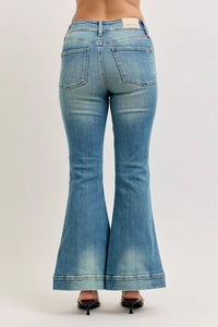 Blue flared jeans on a plain background