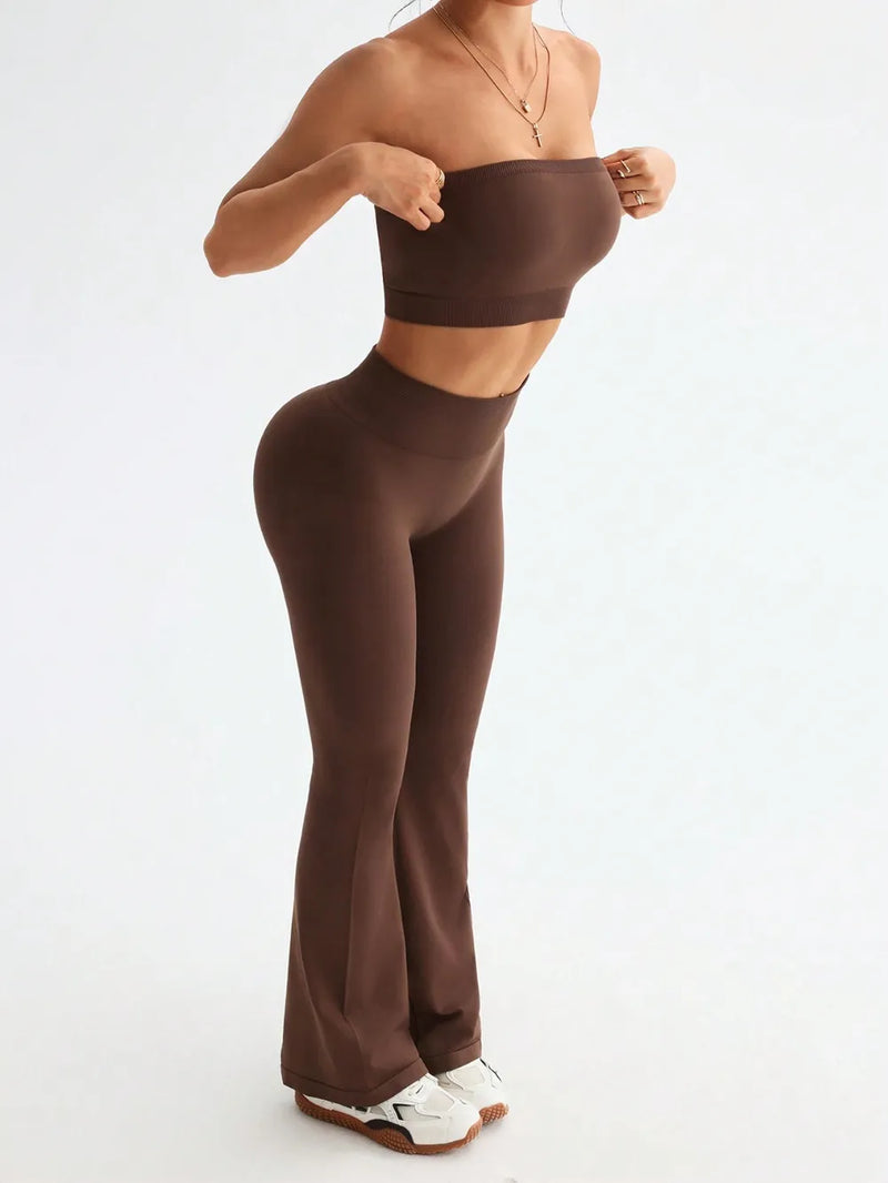 Person wearing brown high-waisted leggings and a matching crop top on a white background