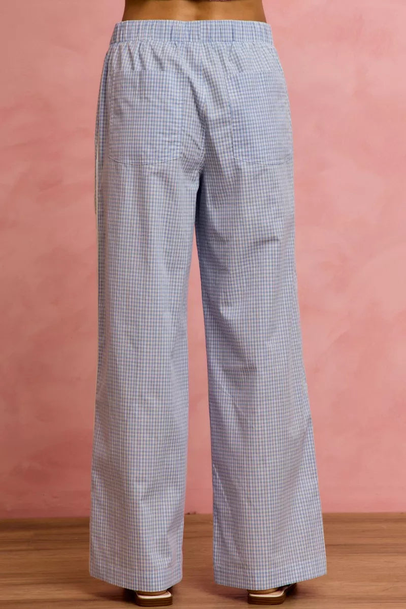 Checkered pants worn by a person on a pink background