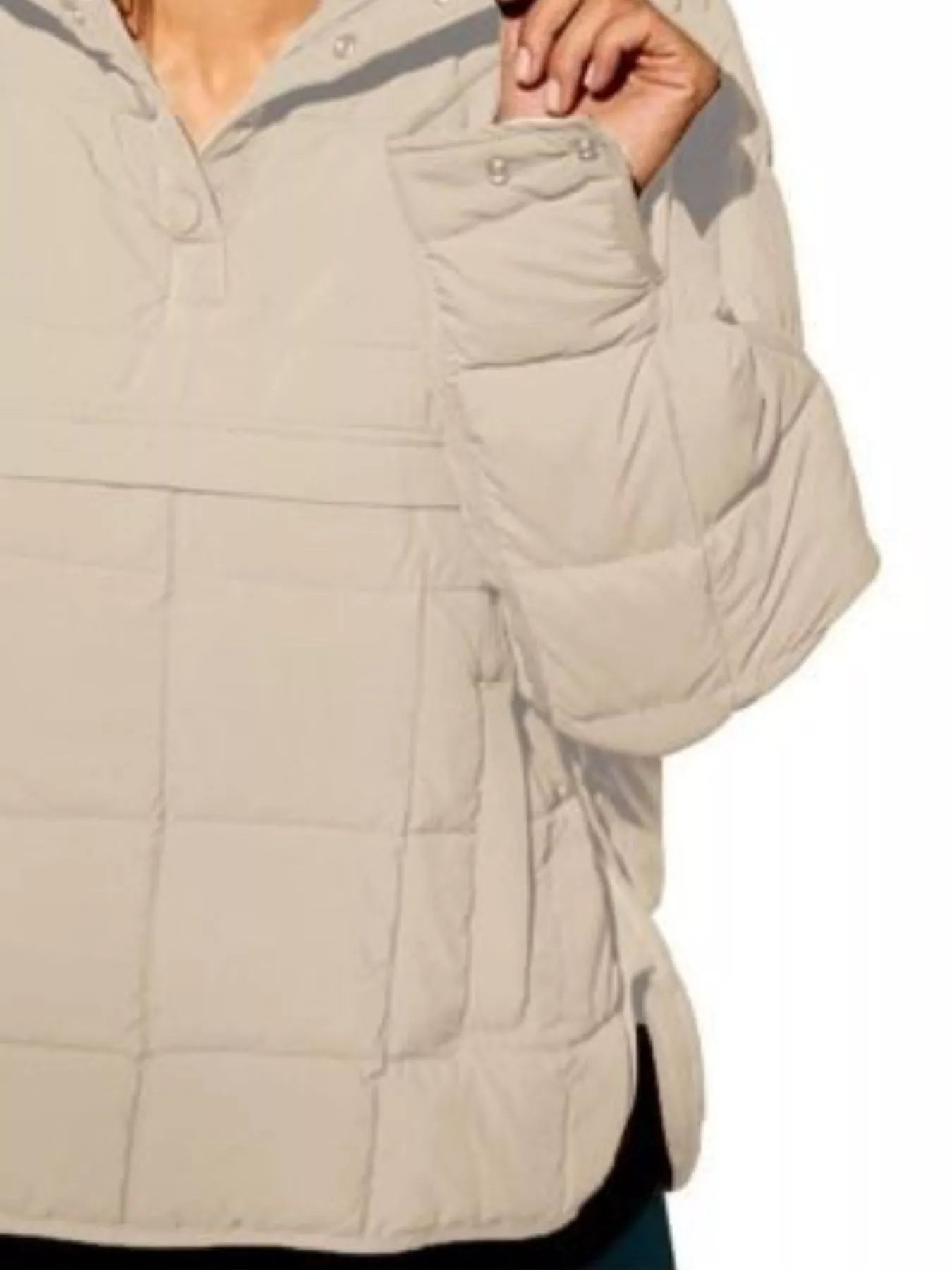 Beige quilted jacket with a focus on the chest area on a white background