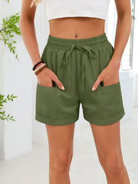 Person wearing green shorts with a white background