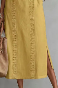 Yellow dress with intricate lace detailing on a gray background