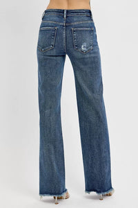 Blue jeans with a distressed back pocket design on a white background