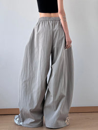 Person wearing light gray wide-leg pants against a plain background