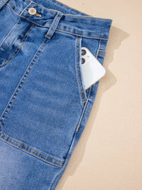 Blue jeans with a smartphone peeking out from a pocket on a beige background