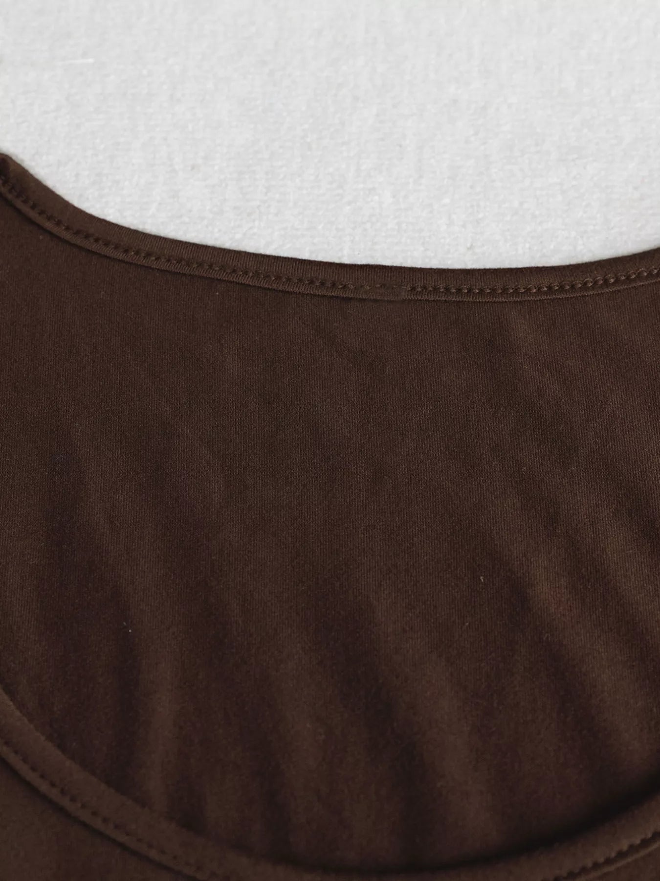 Close-up of brown fabric with a white textured background