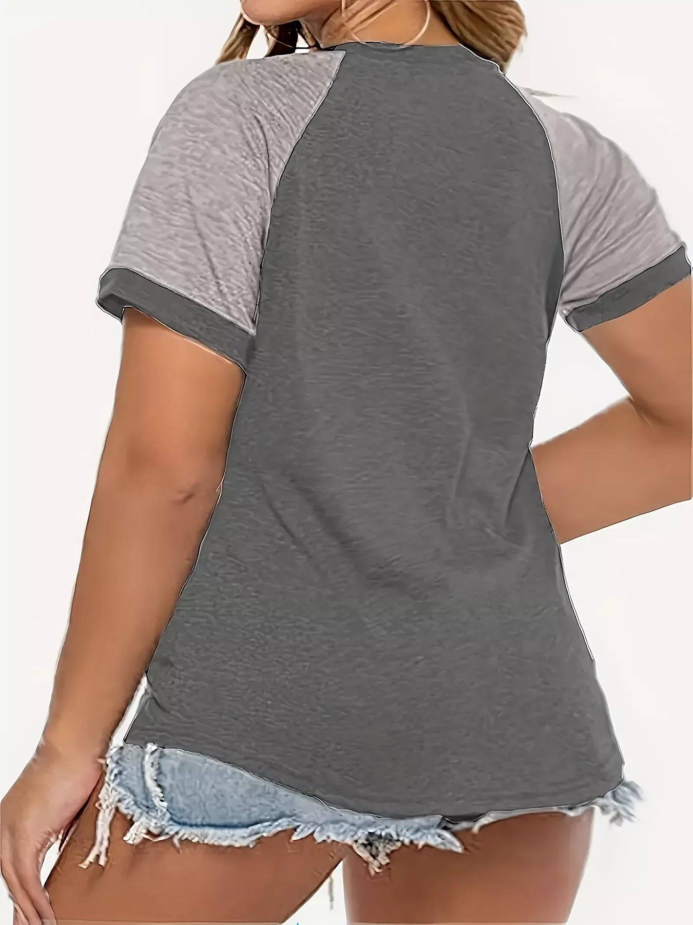 Gray and white baseball-style t-shirt worn by a person on a white background
