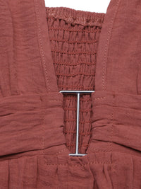 Close-up of a rust-colored garment with a metal buckle