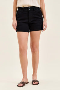 Person wearing black shorts on a beige background