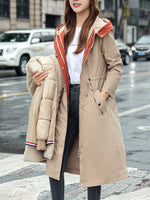 A lady wearing a biege Women's Detachable Longline Hooded Parka with Faux Fur Trim and Drawstring Waist while holding the lining of the coat