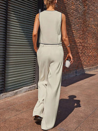 Person wearing a light gray jumpsuit walking on a street.