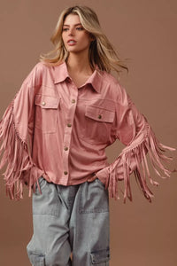 Woman wearing a pink fringed jacket against a brown background