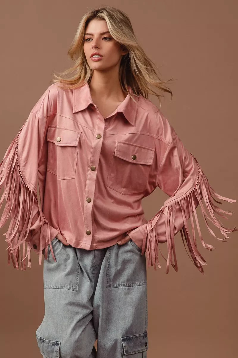 Woman wearing a pink fringed jacket against a brown background