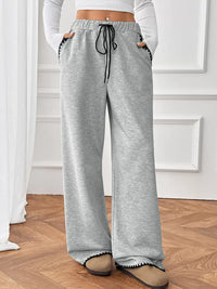 Person wearing gray sweatpants with a white background