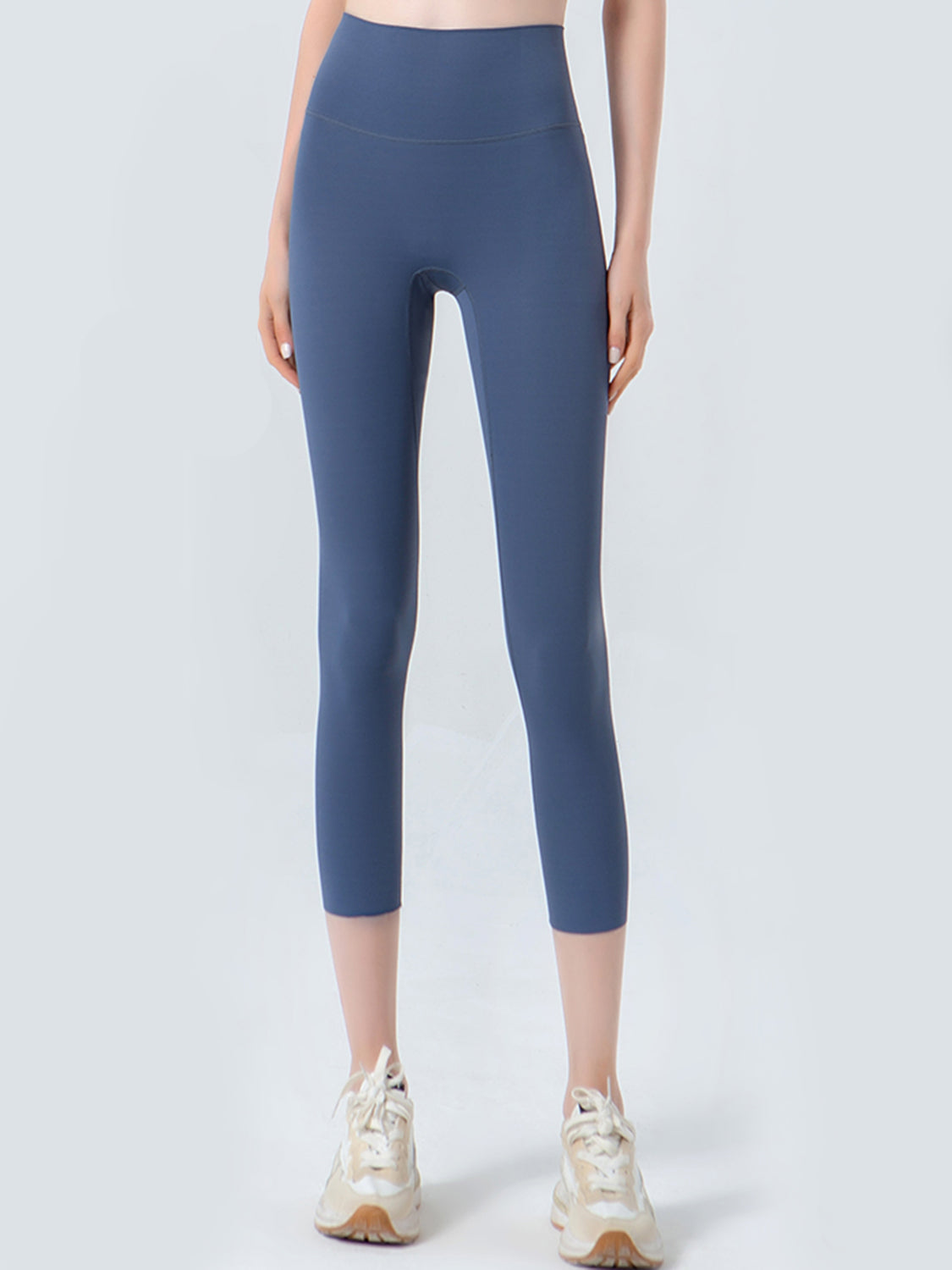 Person wearing blue leggings on a white background