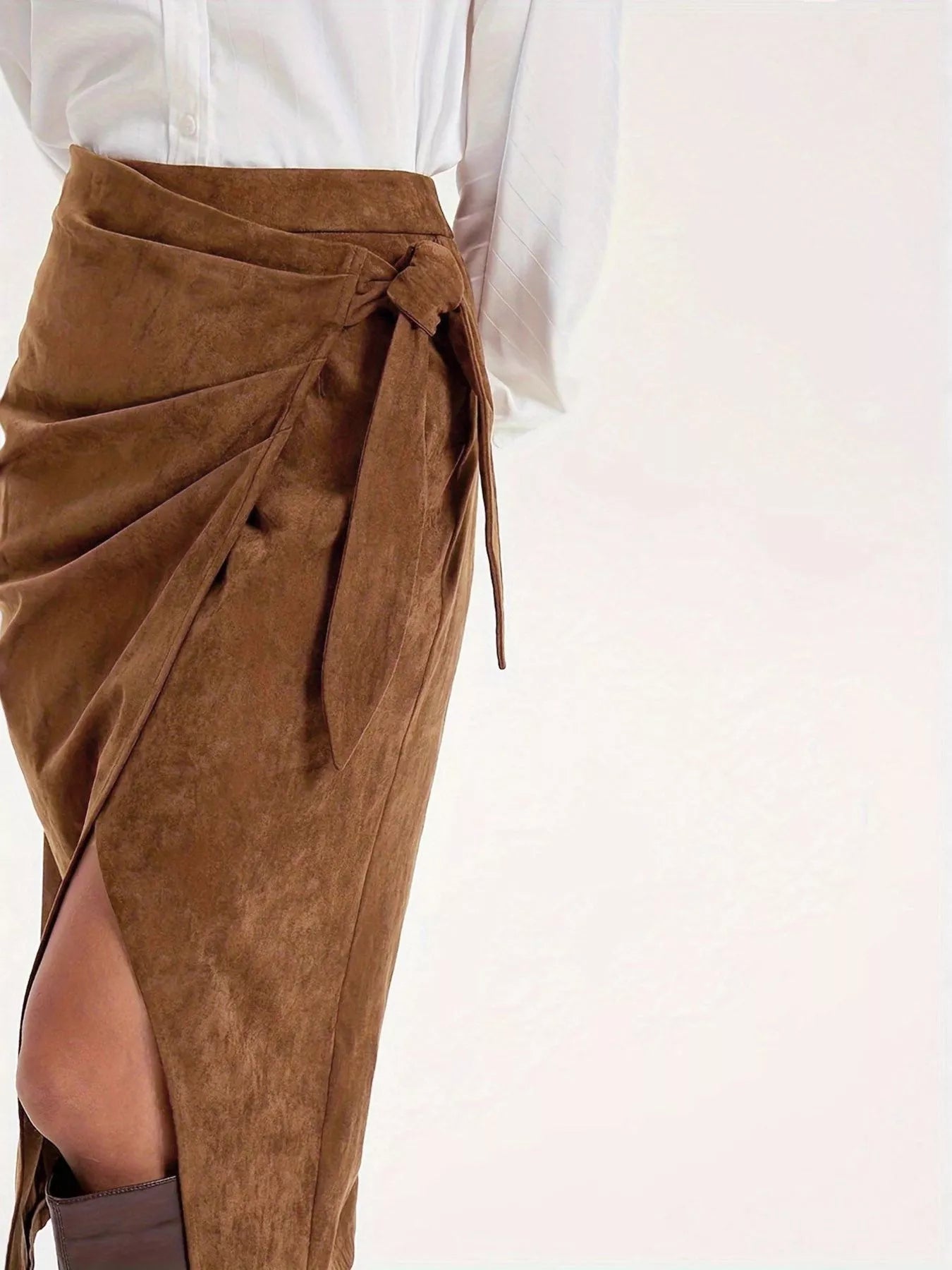 Brown suede wrap skirt with a white blouse on a light pink background