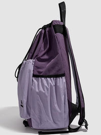 Purple drawstring bag with a smaller compartment on a light gray background