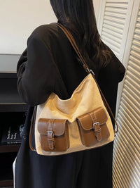 Person wearing a beige handbag with brown accents