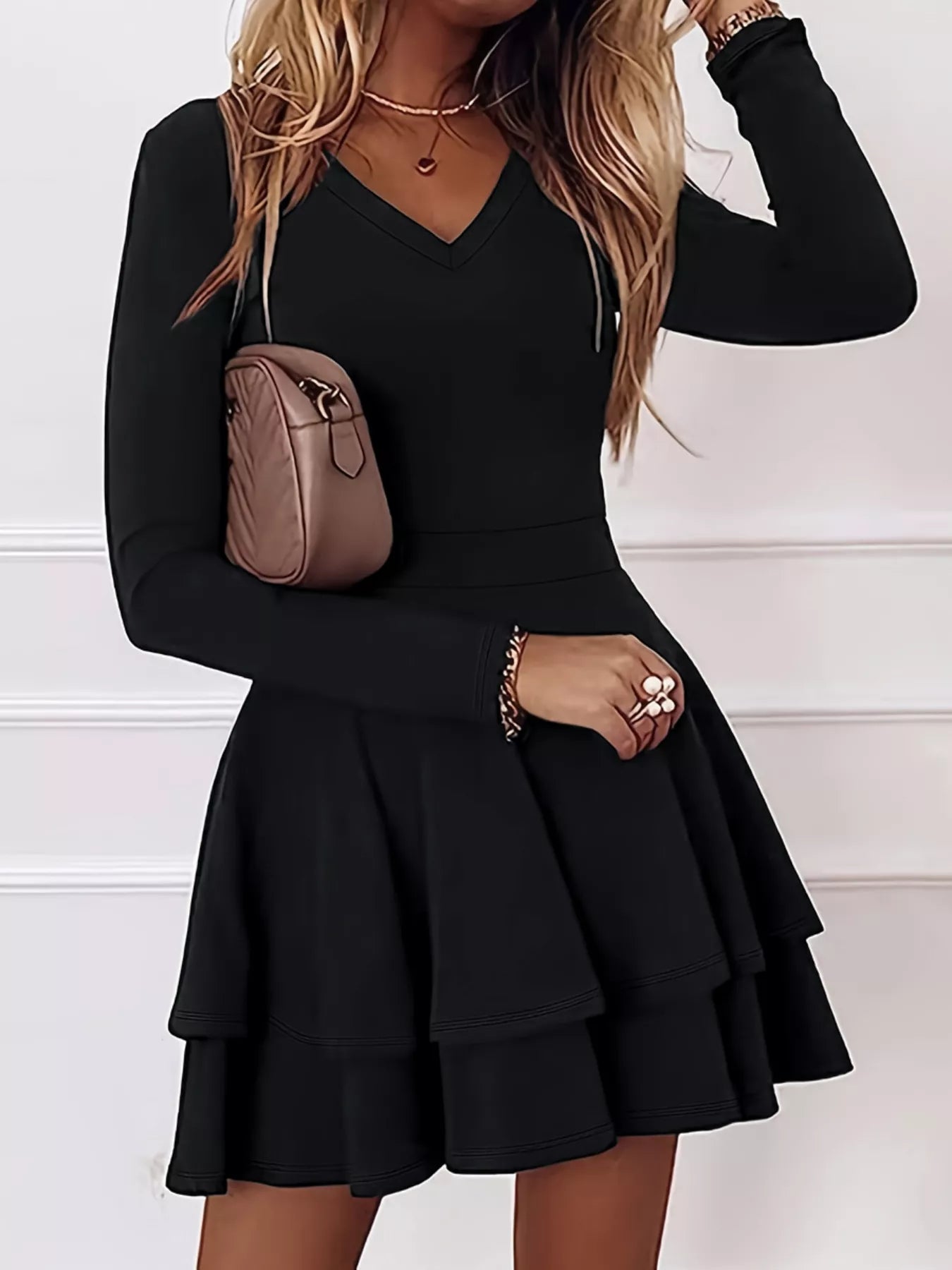 Black long-sleeve dress worn by a person with a neutral background