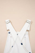 White overalls with blue buttons on a beige background