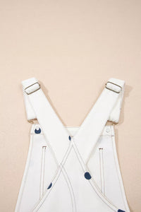 White overalls with blue buttons on a beige background