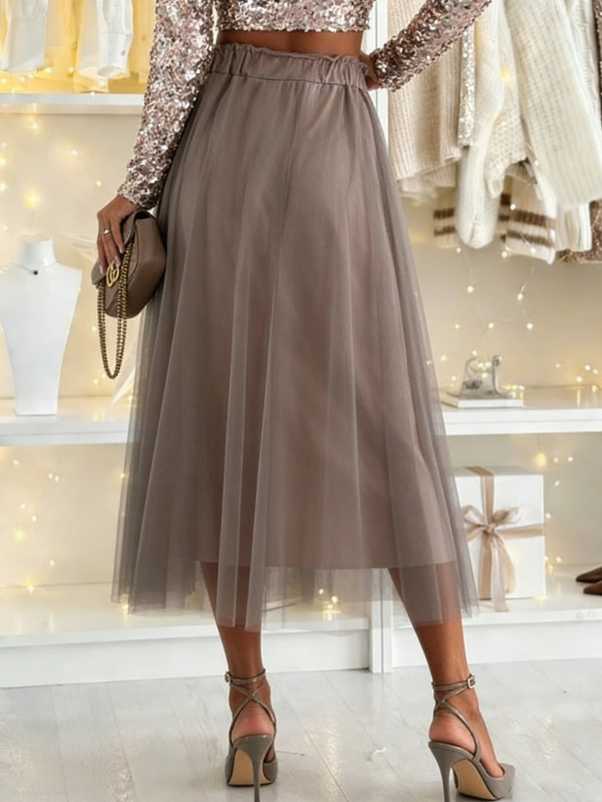 Person wearing a sparkly top and tulle skirt in a store setting.