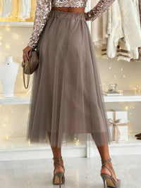 Person wearing a sparkly top and tulle skirt in a store setting.