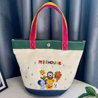 Tote bag with colorful handles and cartoon characters on a blue curtain background