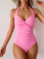 Pink one-piece swimsuit worn by a model on a plain background