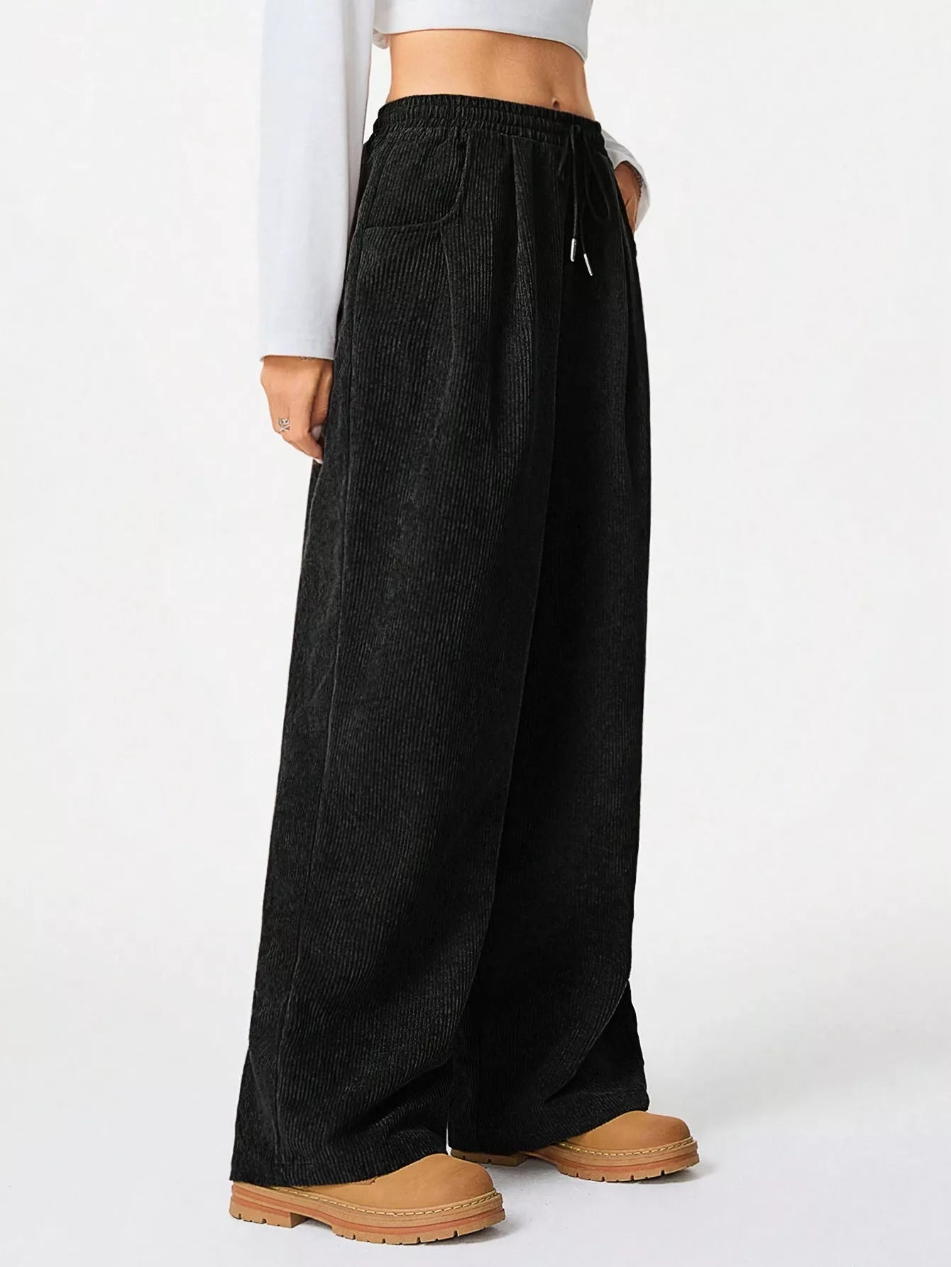 Black wide-leg pants worn by a person on a white background