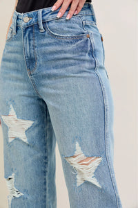 Blue jeans with star designs on a plain background
