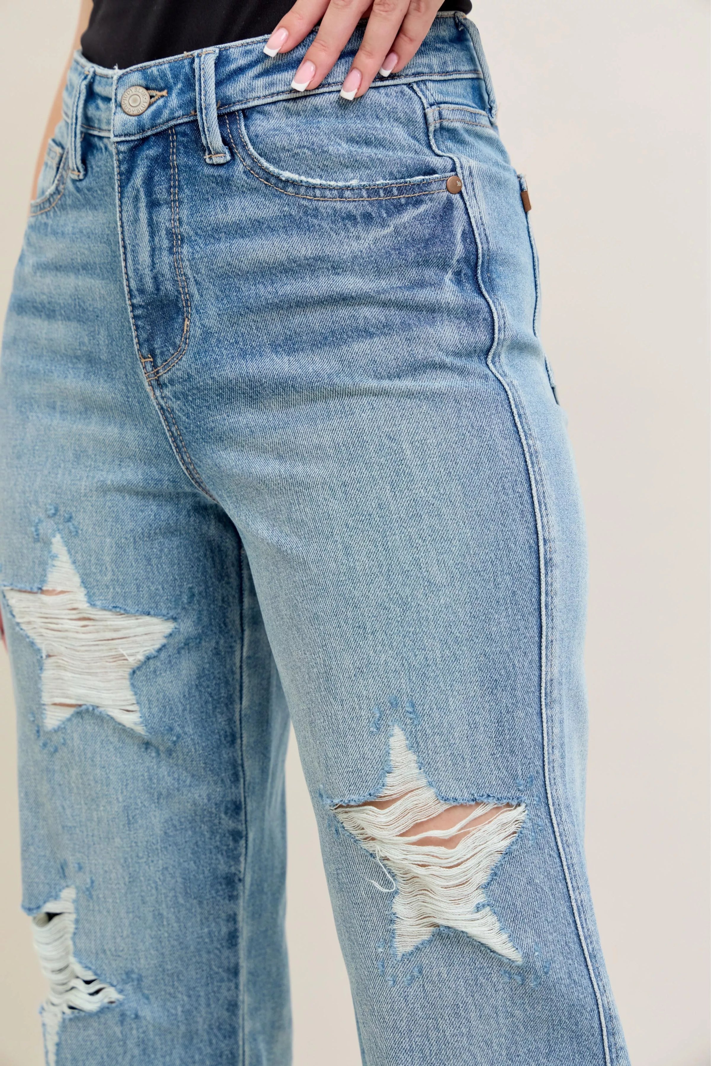 Blue jeans with star designs on a plain background