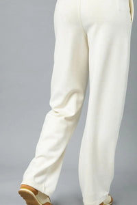 White pants worn by a person on a gray background