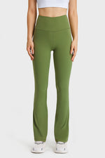Person wearing green leggings and white top on a light gray background