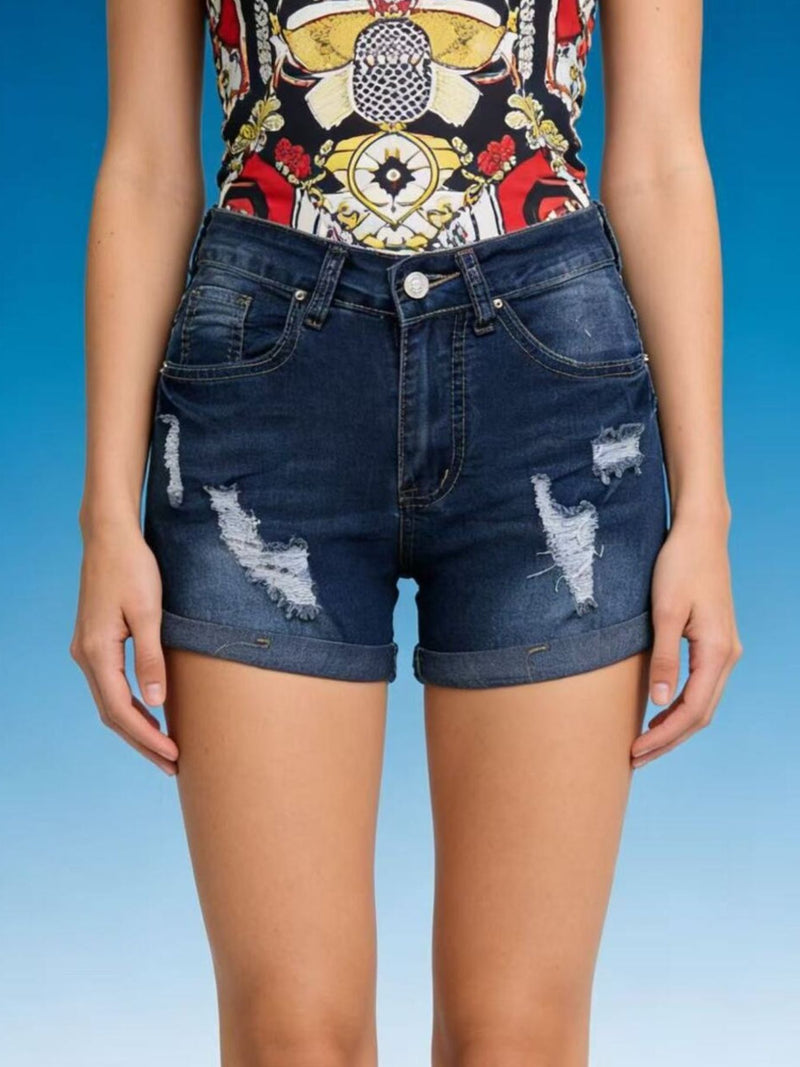 Person wearing a colorful top and blue denim shorts on a gradient background