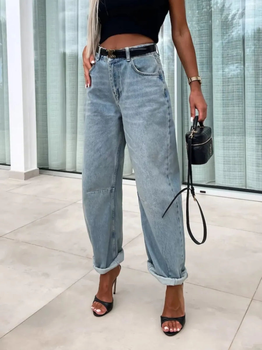 Person wearing light blue jeans and black high-heeled shoes indoors.