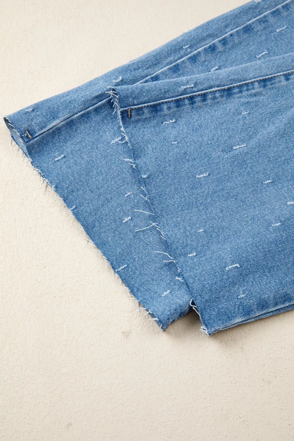 Close-up of blue denim fabric on a beige background
