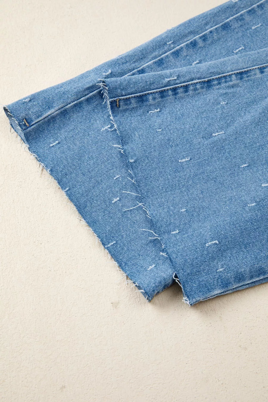 Close-up of blue denim fabric on a beige background