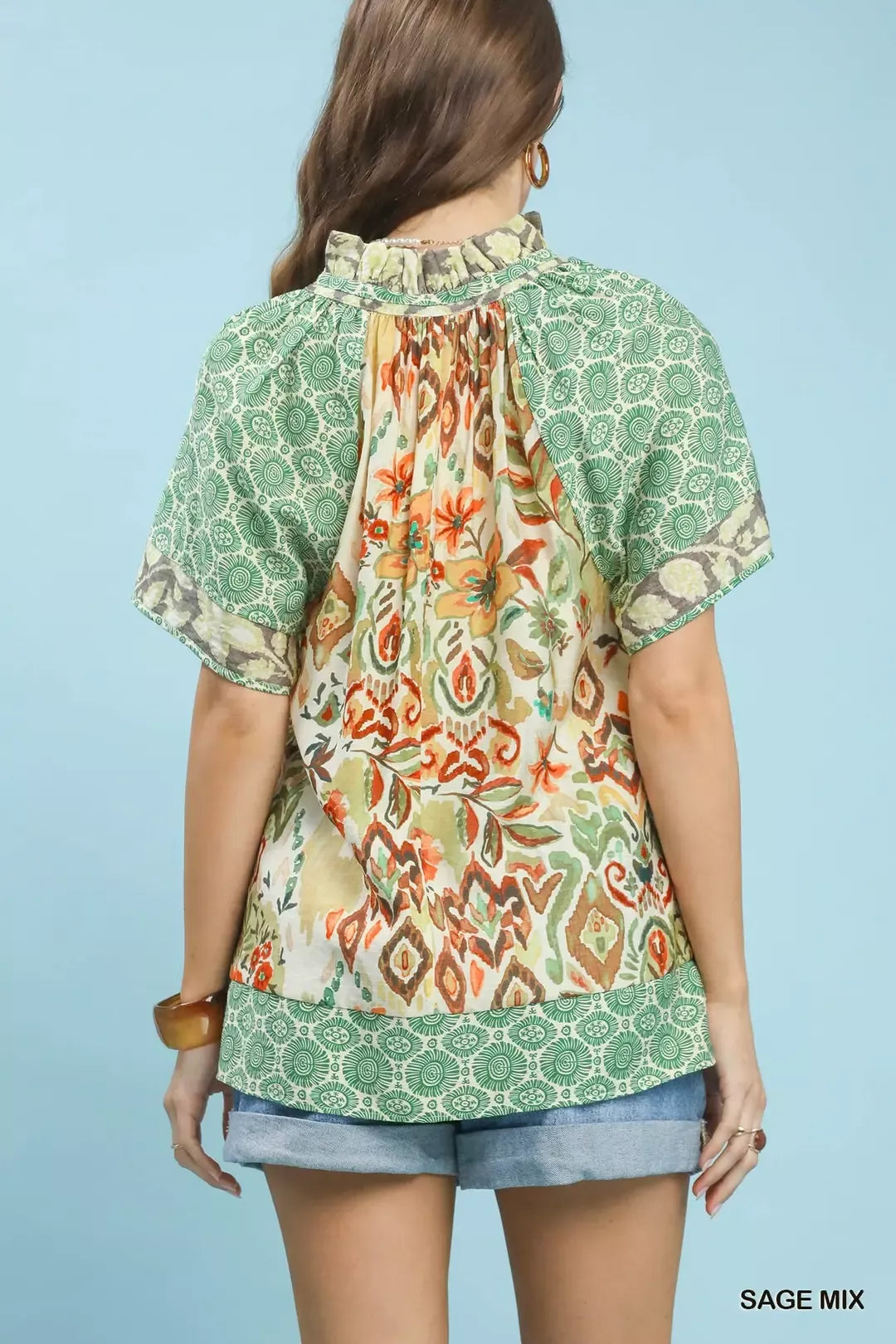 Woman wearing a patterned top with a blue background