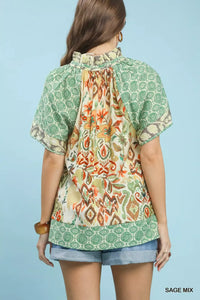 Woman wearing a patterned top with a blue background