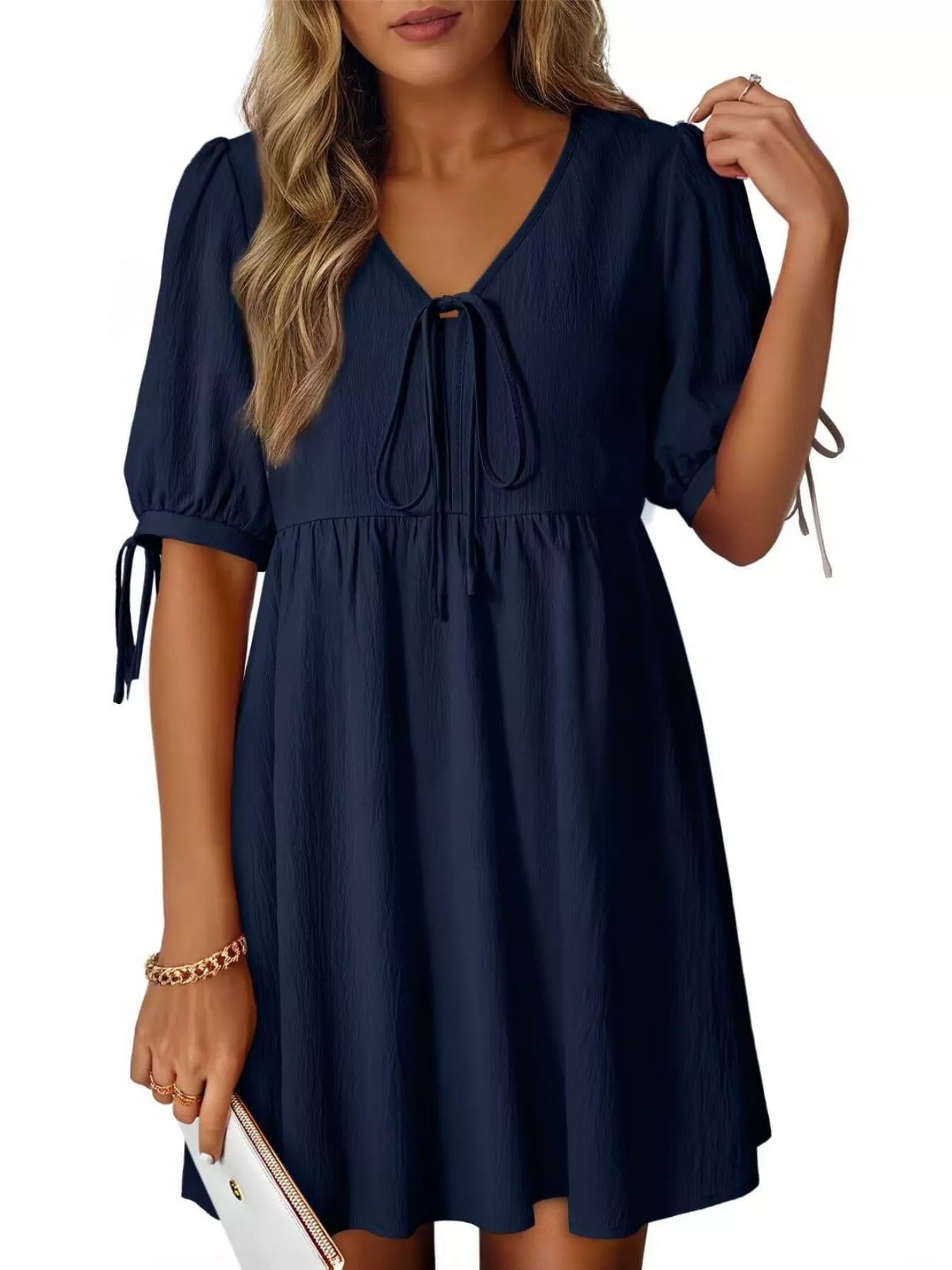 Navy blue dress with puff sleeves and tie details on a white background