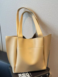 Yellow tote bag on a surface with a neutral background