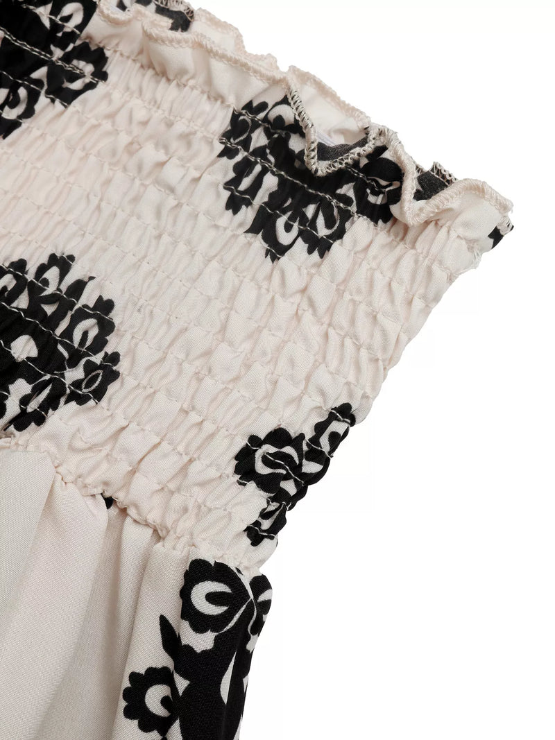 Close-up of a garment with black floral patterns on a white background