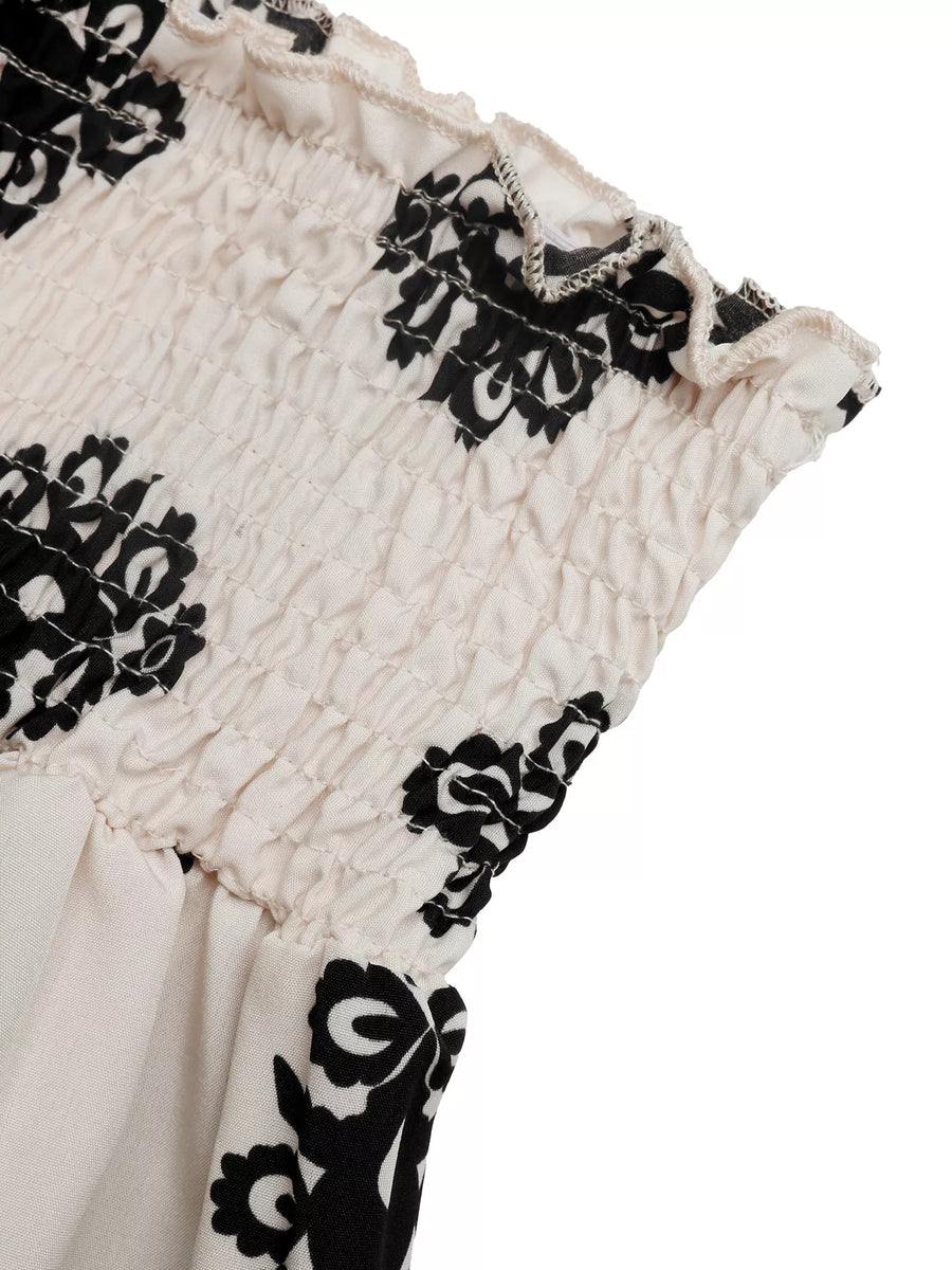 Close-up of a garment with black floral patterns on a white background