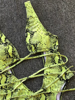 Neon green snake print lace-up top on a textured gray background
