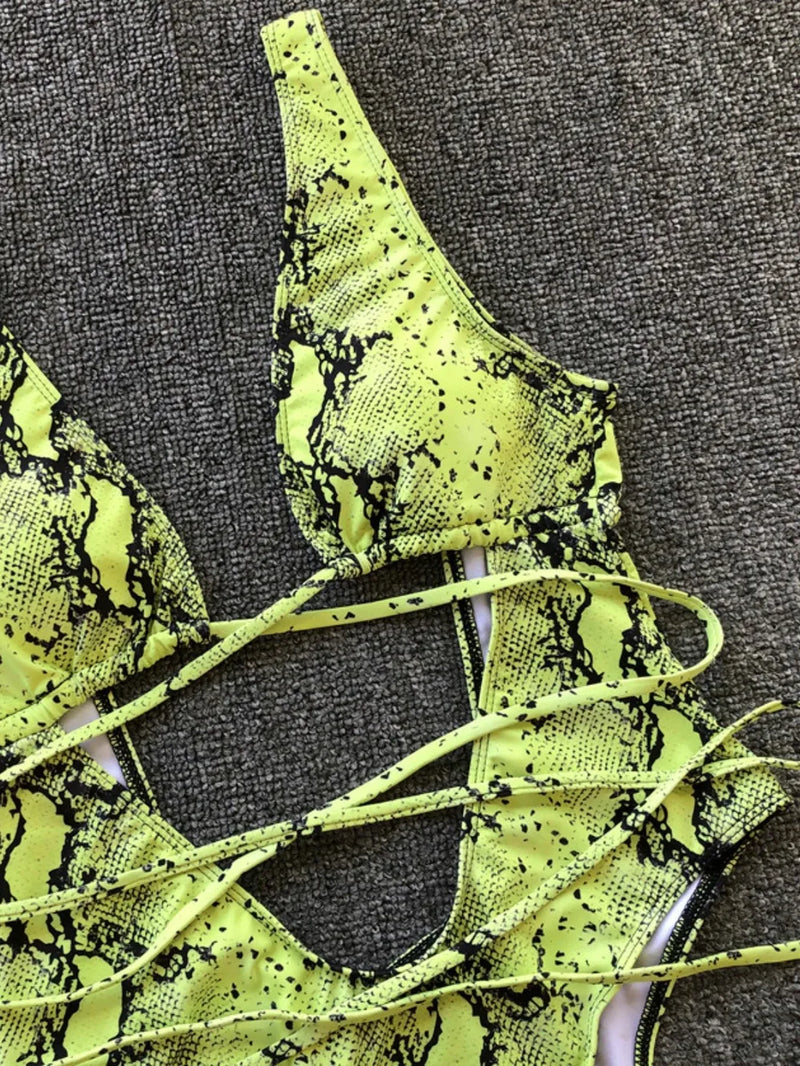 Neon green snake print lace-up top on a textured gray background