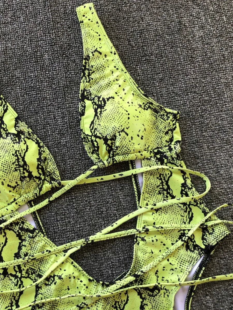 Neon green snake print lace-up top on a textured gray background